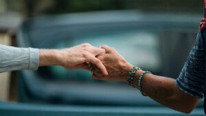 Dos manos entrelazadas que transmiten apoyo y empatía, simbolizando la importancia de acompañar a quienes atraviesan situaciones difíciles.